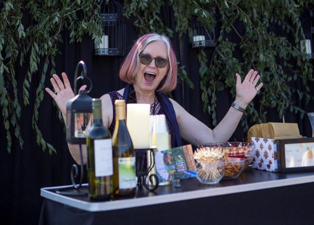 Tish McAllis at the open bar serving beer, wine and hurricanes.